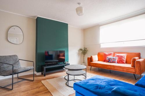 a living room with a couch and a tv at North Elgin Apartment in Clydebank