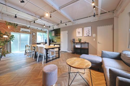 a living room with a couch and a table at Oneness House Tokyo 東京四ツ木 in Tokyo