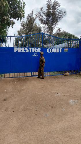 a man standing in front of a blue fence at IL Rubino in Ruiru
