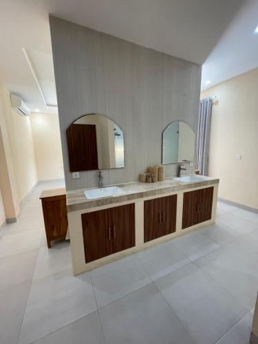 a bathroom with a sink and two mirrors at Luxury 3 Bed Villa in Kuta with Pool in Kuta Lombok