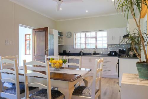 a kitchen with a wooden table and a dining room at High Season Farm Luxury Cottages in Hermanus