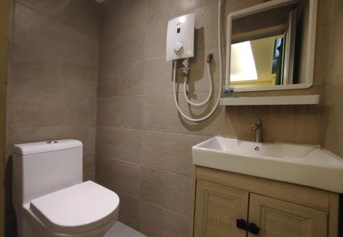 a bathroom with a toilet and a sink and a mirror at Fast Hotel Setapak Near Tunku Abdul Rahman UMT KL in Kuala Lumpur
