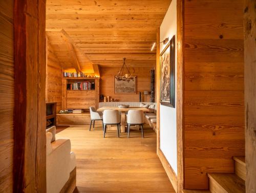 a dining room and kitchen with wooden walls and wood floors at Tablà del Bosco R&R in Cortina dʼAmpezzo