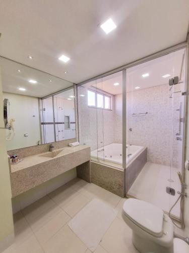 a bathroom with a shower and a toilet and a tub at Diamante Rosa Palace Hotel in Coromandel