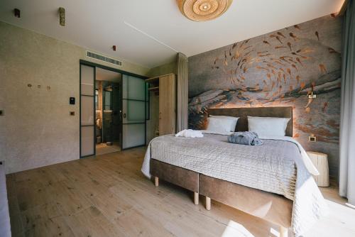 a bedroom with a large bed with a painting on the wall at Das SeeDorf - exklusive Ferienhäuser am Wasser in Görlitz