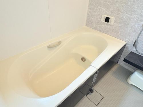 a white bath tub in a white bathroom at 夏様星 Cozy House near Kamogawa River in Kyoto