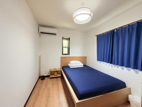 a bedroom with a blue bed and a window at 夏様星 Cozy House near Kamogawa River in Kyoto