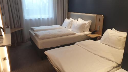 a hotel room with two beds and a window at Holiday Inn Express - Lustenau in Lustenau