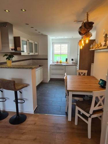 a kitchen with a wooden table and a dining room at Waldstein Terrassen in Weißenstadt