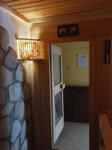 an open door to a room with a stone wall at Haus Waldfrieden EG in Thalfang