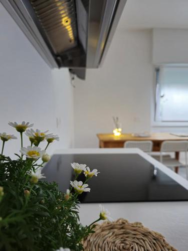 a table with a laptop and flowers on it at La casa delle margherite - Tirano in Tirano