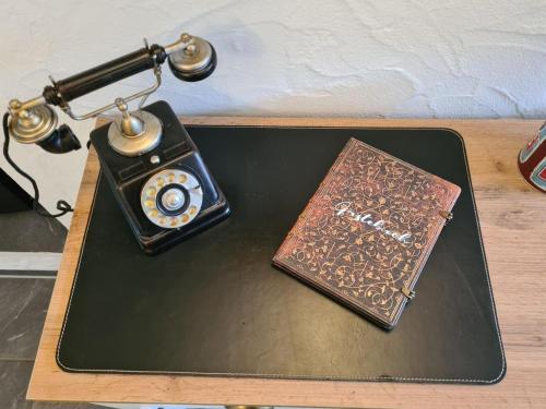 a table with a phone and a book on it at Haus Waldstein Single in Weißenstadt