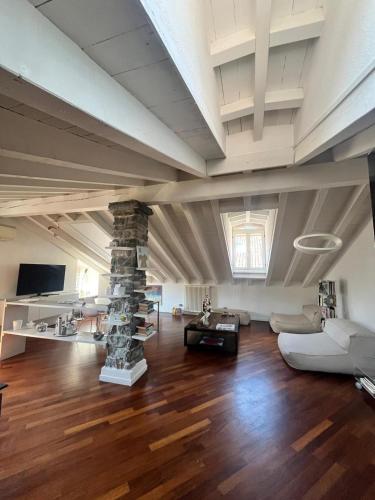 a large living room with a stone pillar and a couch at Vanessa's Art Rooftop Attic - City View - San Fedele, Historic Center Como in Como