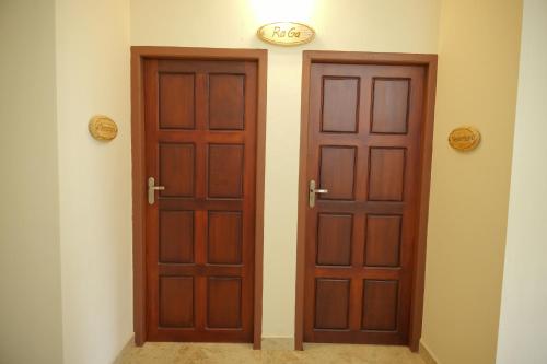 two wooden doors in a room with at Ra Ga Riverside - 2 Bedroom Retreat in Kumarakom