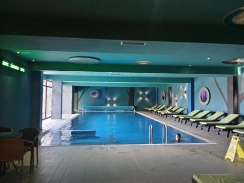 a pool in a hotel with chairs around it at Studio SimpaKop in Kopaonik