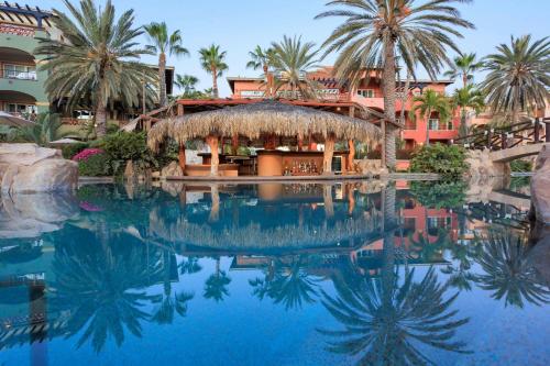 a pool at a resort with palm trees and a building at Hacienda del Mar Los Cabos, an Autograph Collection All-Inclusive Resort in Cabo San Lucas