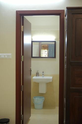a bathroom with a sink and a mirror at Ra Ga Riverside - 2 Bedroom Retreat in Kumarakom