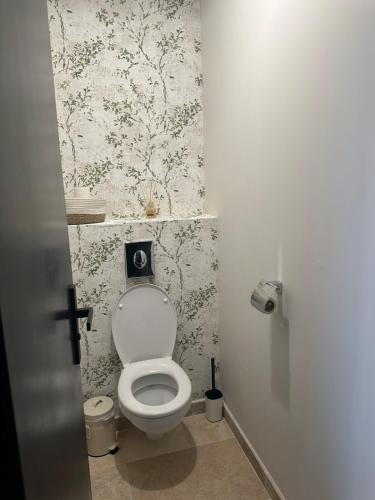bagno con servizi igienici e carta da parati floreale di Le Fort 6 - Appartement neuf 6p a LʼIsle-sur-la-Sorgue