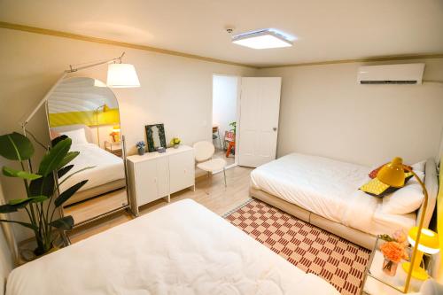 a bedroom with two beds and a mirror at stay DAHOM in Seoul