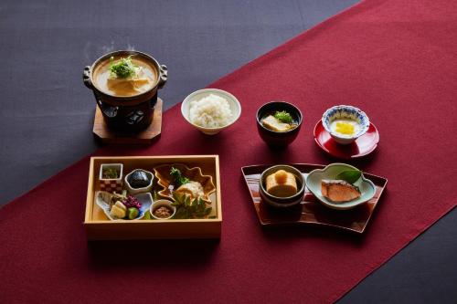 a table topped with plates of food and bowls of food at Kyoto Hot Spring Hatoya Zuihokaku Hotel in Kyoto