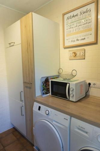 a microwave on a counter next to a washing machine at Haus Sonnenblick in Thalfang