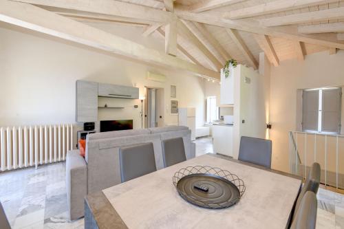 a kitchen and living room with a table and chairs at La Darsena by Garda FeWo in Montecucco