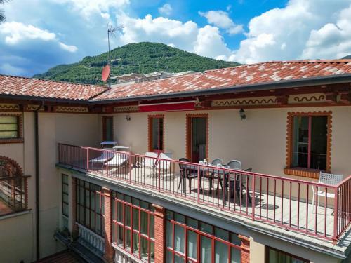 a building with a balcony with tables and chairs at La Darsena by Garda FeWo in Montecucco