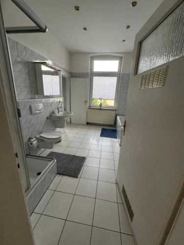 łazienka z dwiema toaletami, wanną i umywalką w obiekcie Stilvolle Altbau Wohnung im Zentrum von Detmold, Paulana w mieście Detmold