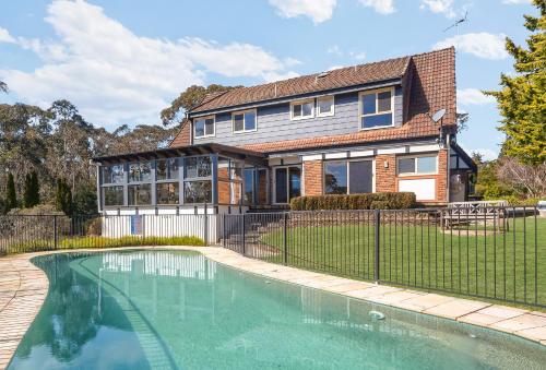 a house with a swimming pool in front of a house at The Manor in Blue Mountains in Wentworth Falls