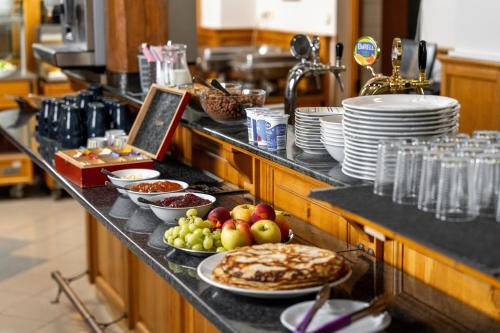 a kitchen counter with plates of food on it at Hotel Macocha in Blansko