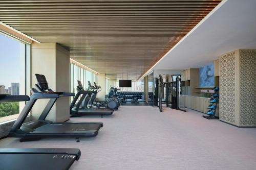 a gym with a row of treadmills and machines at Courtyard by Marriott Korla in Korla