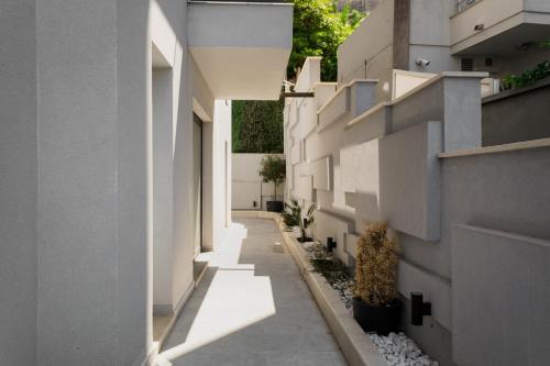 an alley between two white buildings with plants at Faro Home in Rafailovici