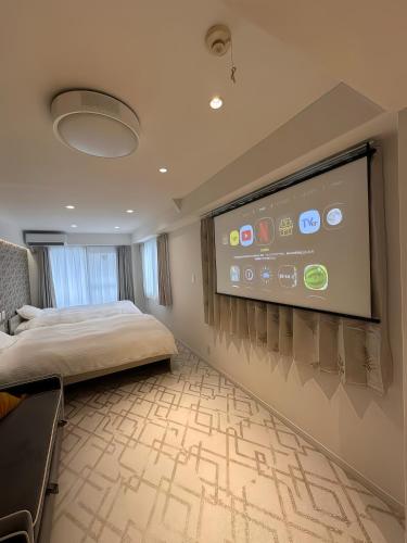 a bedroom with a large screen in the wall at Louis House Otsuka Nishi in Tokyo
