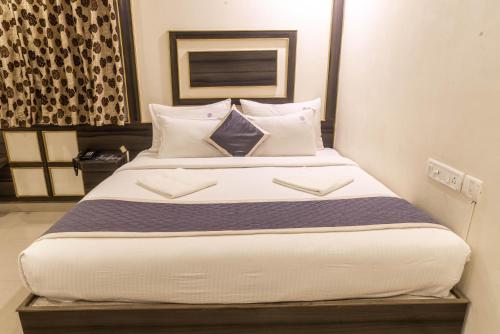 a bedroom with a large bed with white sheets and pillows at Hotel Comfort Park - Opposite Sri Ramachandra Medical College Porur in Chennai
