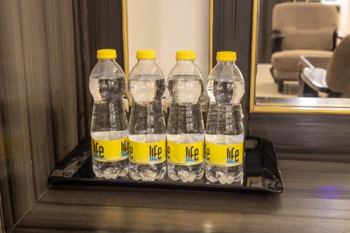 a group of four bottles of water in front of a mirror at Hotel Comfort Park - Opposite Sri Ramachandra Medical College Porur in Chennai