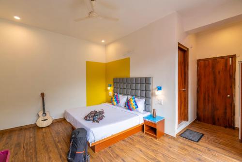 a bedroom with a bed and a guitar in it at goSTOPS PLUS Kasol, Suma Ropa in Kasol