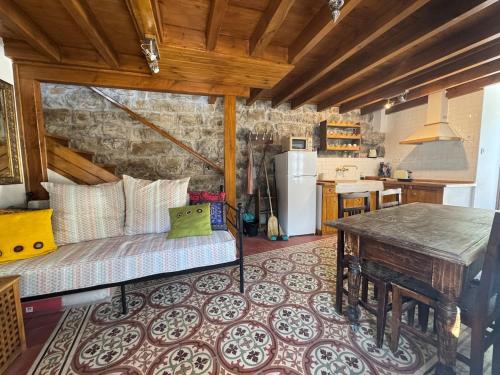 a kitchen with a couch and a table in a room at La Casuca de la Brevera in Pesaguero-La Parte
