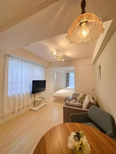 a living room with a couch and a television at Louis House Otsuka Nishi in Tokyo