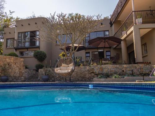 a swimming pool in front of a house at 8 On Penny Guesthouse in Nelspruit