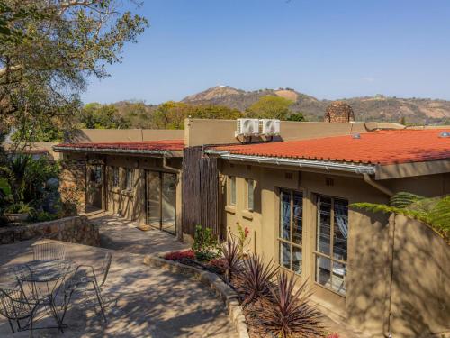 a house with a patio and a roof at 8 On Penny Guesthouse in Nelspruit