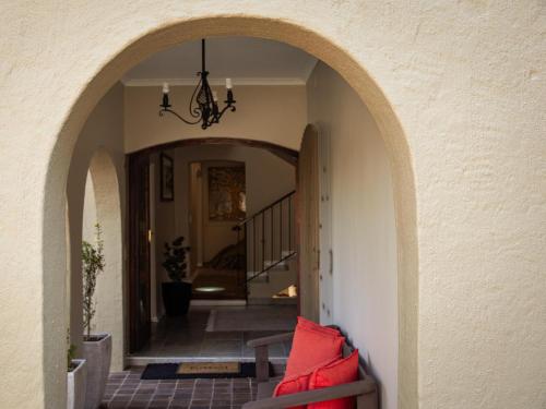 an archway leading into a hallway with red pillows at 8 On Penny Guesthouse in Nelspruit