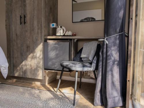 a chair in front of a desk with a television at 8 On Penny Guesthouse in Nelspruit