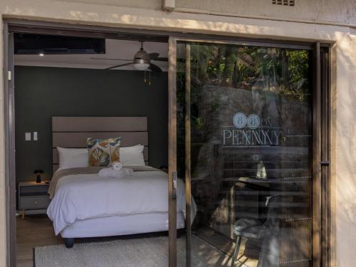 a bedroom with a bed and a sliding glass door at 8 On Penny Guesthouse in Nelspruit