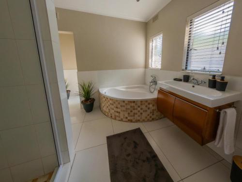 a bathroom with a tub and a sink at 8 On Penny Guesthouse in Nelspruit