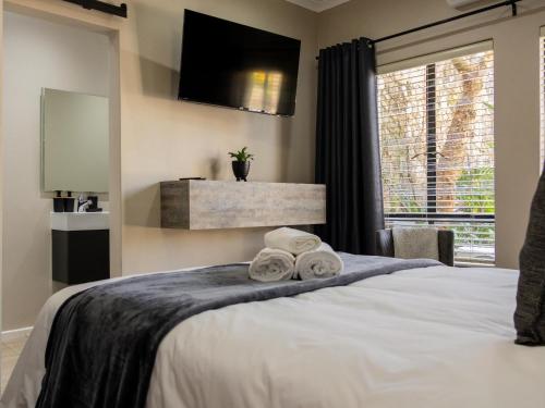 a bedroom with a bed with towels on it at 8 On Penny Guesthouse in Nelspruit