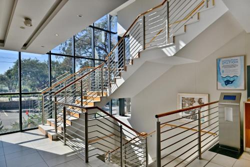 a staircase in a building with glass windows at City Lodge Hotel Waterfall City in Midrand