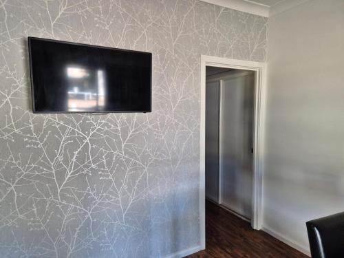 a living room with a tv on a wall at Heritage Caravan Park - Pet Friendly in Alice Springs
