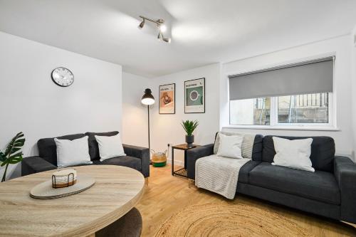 a living room with a couch and a table at Luxury Lower-Level Two Bed Apt in Headingley