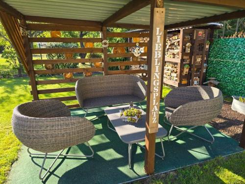 three chairs and a table under a gazebo at Ferienhaus Müllrose am Wald in Müllrose