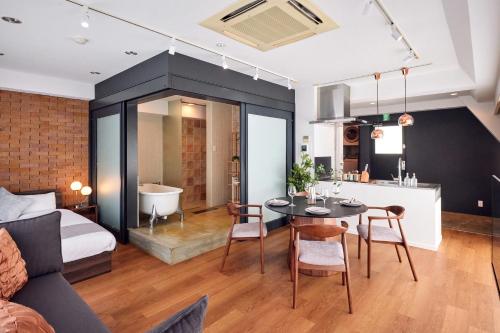 a room with a bed and a table and a bath tub at R STAY Shiba in Tokyo